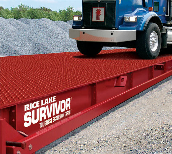 A red colored Rice Lake Survivor ATV Truck Scale sits below an 18 wheeler that's driving onto it..