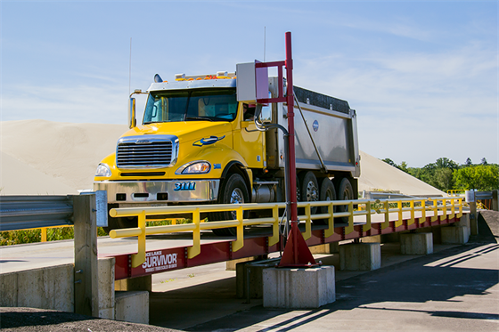 A truck is positioned directly on an industrial truck scale from Rice Lake.