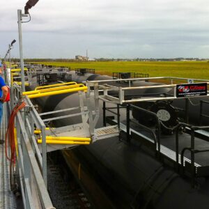 A Telescoping Loading ramp projected out onto a tanker car cage system for fueling.
