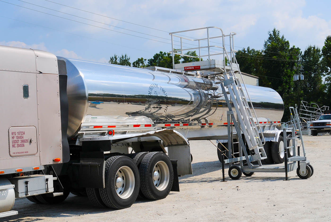 A Carbis portable tanker truck access system is pulled up onto a tank car.