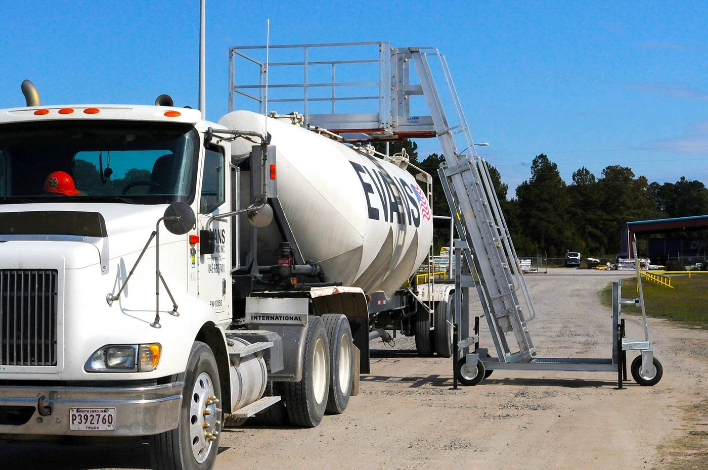 A Carbis portable tanker truck access system is pulled up onto a tank car.
