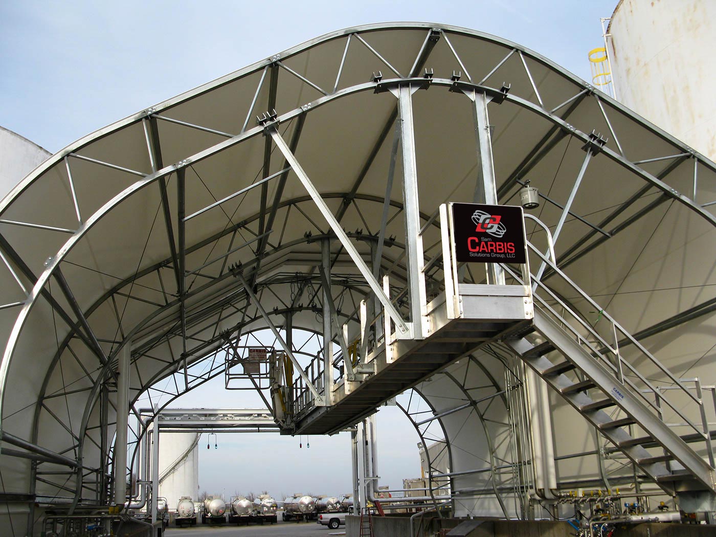 Multi-hatch truck loading system under a hanger.