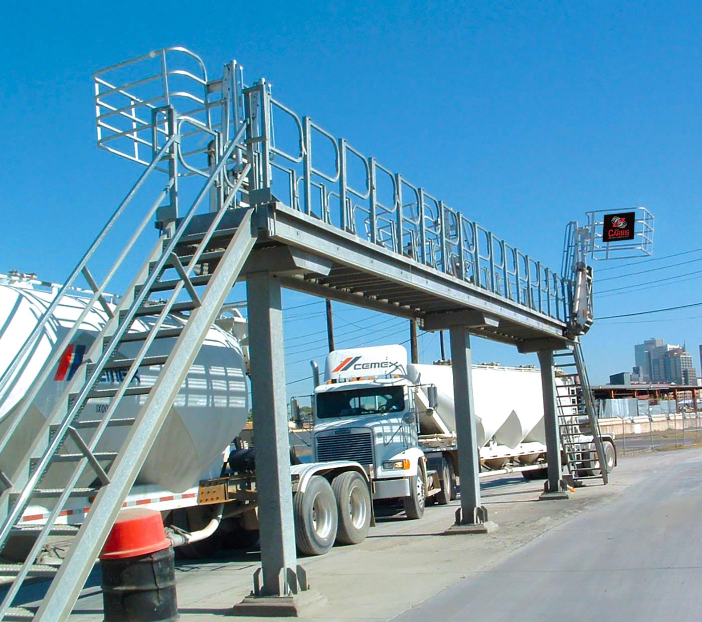 Multi-hatch truck loading system above a road where trucks are driving under.
