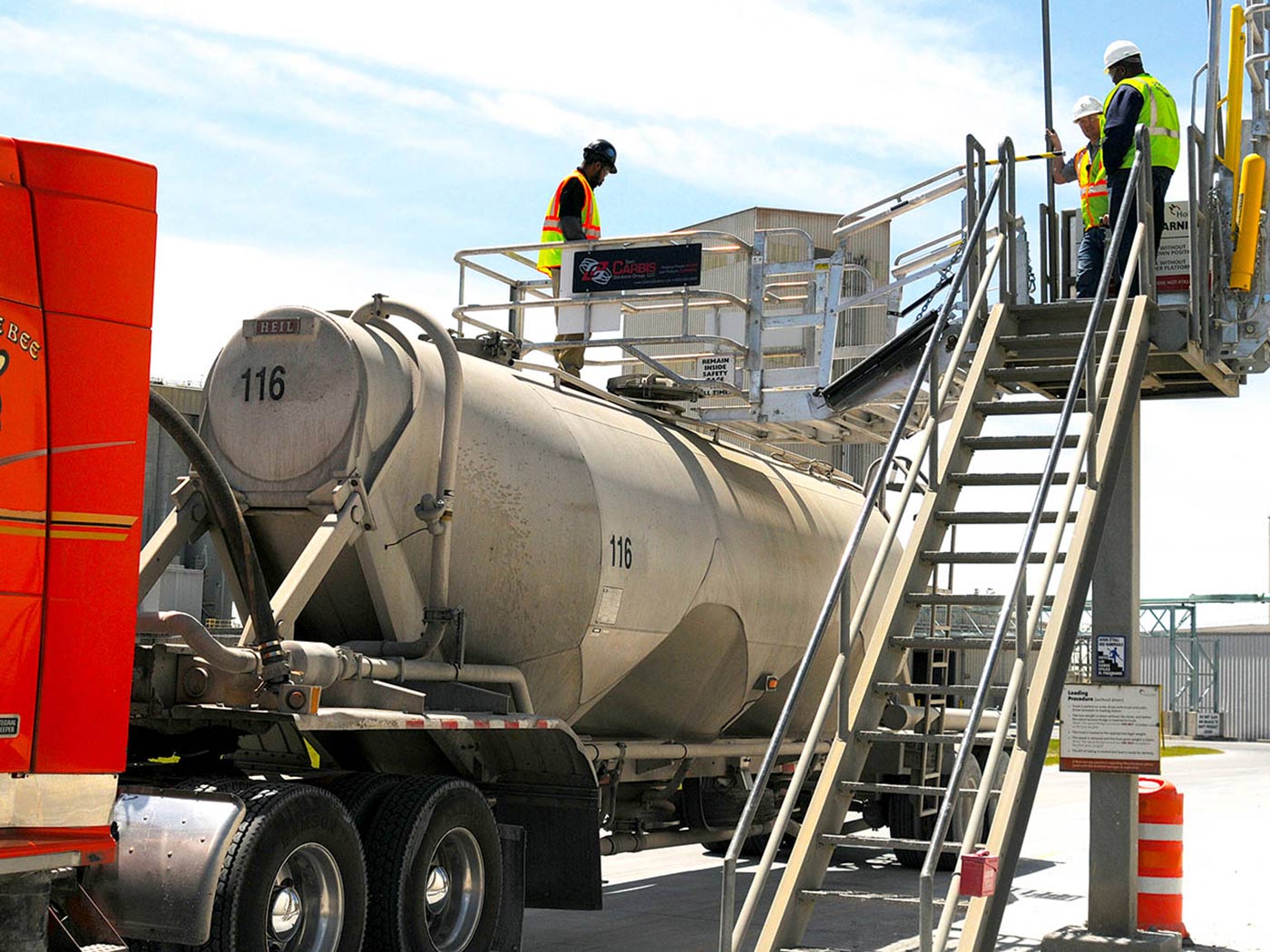 Carbis single hatch truck loading system above a tank truck's vessel.