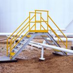 A crossover stairway over a pipeline in a refinery.