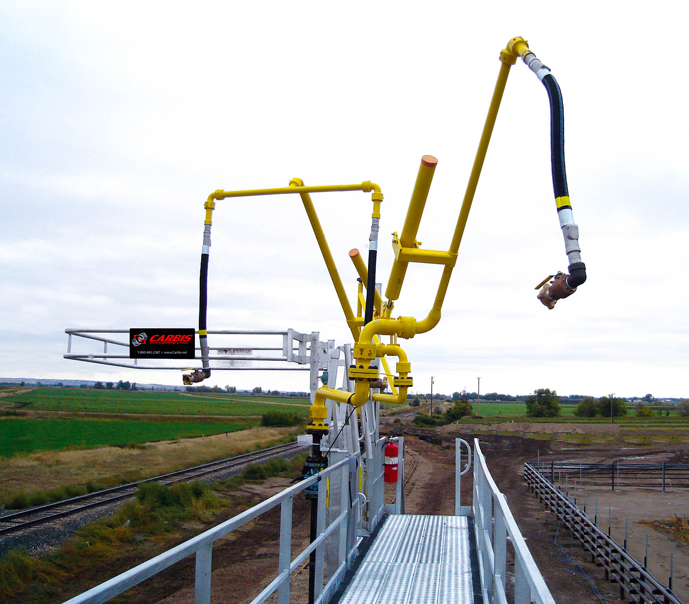 A top loading arm sits above a catwalk on a loading platform.