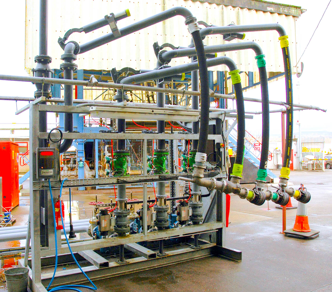 A group of bottom loading arms sit inside a skid, forming a loading bay.