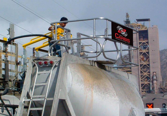 A man is in a Carbis safety cage on top of a tanker truck