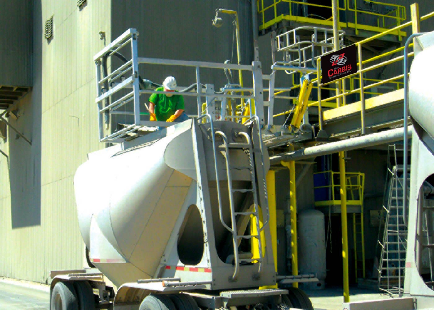 A man is in a Carbis safety cage on top of a tanker truck