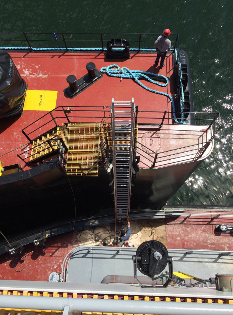 A marine ladder is positioned from one boat to the next for boarding.