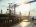 Workers traverse a marine gangway on a barge.
