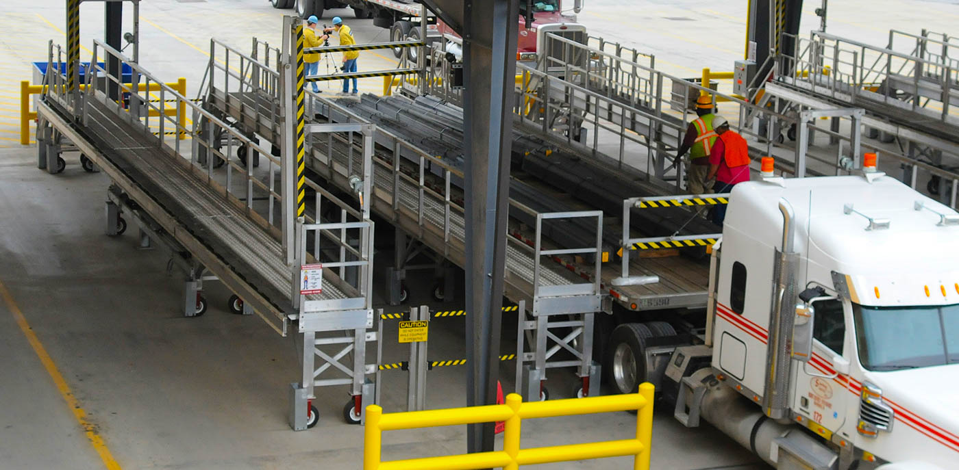overhead view of a tarping bay with the tarping platforms surrounding a trailer.