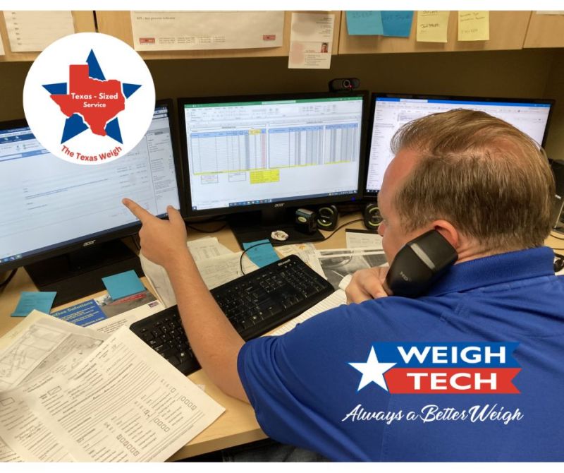 picture of a Weigh-Tech employee pointing at one of three computer screens while he is on the phone.